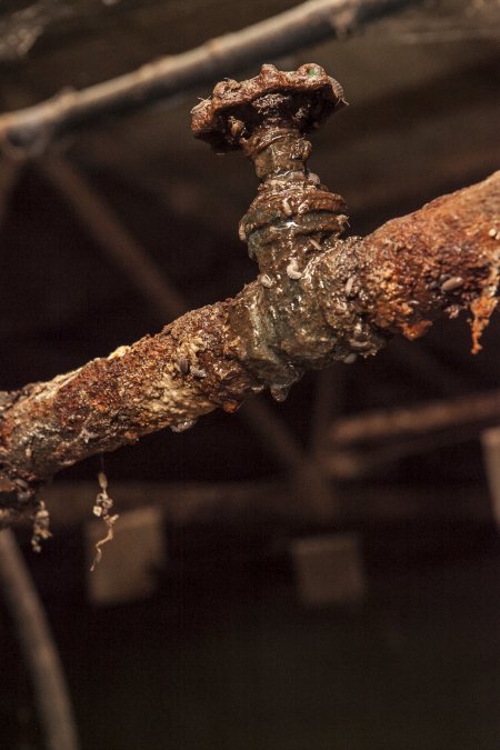 Rusted pipes in empty farrowing shed