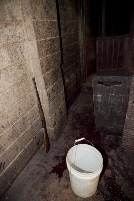 Rifle propped against wall of slaughter room