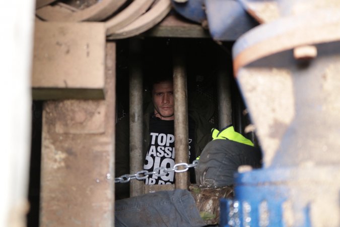 From above, activist lying down in gas chamber gondola