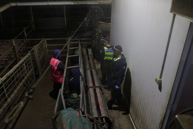 Police speak with activists chained inside race