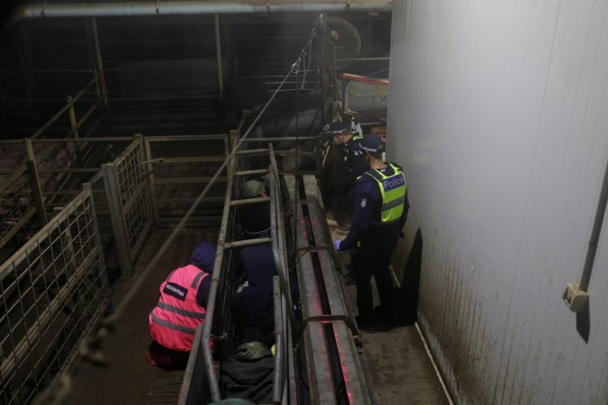 Police speak with activists chained inside race