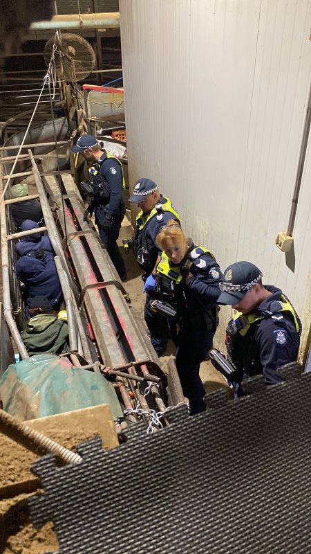 Police speak with activists chained inside race