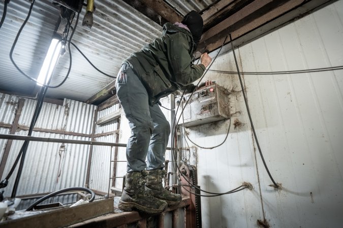 Investigator climbing wall to install hidden camera