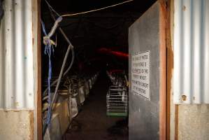 Looking through door into farrowing shed from outside - Sign: 'The taking of photos or film footage is not permitted on this property without prior written consent of the directors' - Captured at Ludale Piggery, Reeves Plains SA Australia.