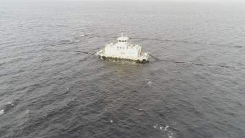 Drone flyover of offshore salmon farm - Floating sea cages containing farmed salmon, in Macquarie Harbour, near Strahan, Tasmania. - Captured at TAS.