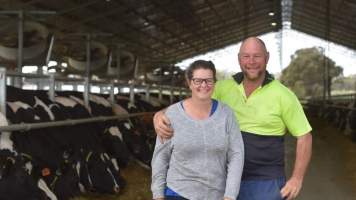 Farmer poses with wife in intensive dairy shed - The Clymo's (