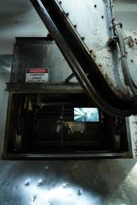Activist sealed inside gondola in gas chamber - TV screen attached to the outside of the gondola, playing footage captured by a hidden camera inside the gondola. - Captured at Benalla Abattoir, Benalla VIC Australia.