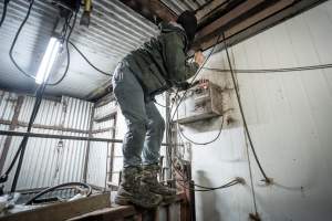 Investigator climbing wall to install hidden camera - Captured at Menzel's Meats, Kapunda SA Australia.