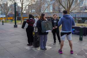 22 June 2025: 5 Question Challenge: Dominion Outreach Melbourne - Animal rights activists participating in a street outreach event in Southbank, Victoria, Australia. Some volunteers hold placards inviting pedestrians to answer 5 questions in exchange for a vegan treat. Others hold TVs showing footage from Farm Transparency Project’s dairy investigations. Together, they bring awareness to the hidden reality of what happens to cows, calves, and bulls in the Australian dairy industry. - Captured at VIC.