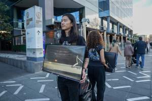 3 August 2025: Dominion Outreach Melbourne: Shut Down Slaughterhouses - Animal rights activists participating in a street outreach event in Southbank, Naarm/Melbourne. Some wear TVs showing footage from Farm Transparency Project's slaughterhouse investigations as part of the Shut Down Slaughterhouses campaign. Others hold placards or engage the public in conversations. Together, they bring awareness to the hidden reality of what happens to animals inside slaughterhouses. - Captured at VIC.