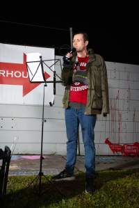 Cedar Meats Vigil - National Week Of Action 2025 - During the Shut Down Slaughterhouses Week of Action, we held a vigil outside of the Cedar Meats slaughterhouse in Brooklyn, Victoria.

During a two week investigation last year, our hidden cameras captured the handling and slaughter of animals, including newborn lambs and kids born in the holding pens of the slaughterhouse.

It was a Wednesday night when we gathered outside the slaughterhouse, holding signs and listening to music and speeches from investigators. We wanted to send a message to Cedar Meats, to let them know that we have not forgotten how they treat animals when they believe that no one is watching

We poured fake blood across their driveway as a visual reminder to everyone passing by, that animals arriving here are coming to their deaths. At the gates to the slaughterhouse, we each left a flower.

The images of animals whose deaths we have seen will haunt us forever, but we are determined to continue to fight in their name. - Captured at Cedar Meats, Brooklyn VIC Australia.