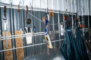 Knives hanging on wall of processing room - Handheld photos taken at Goulburn Valley Stock Removers, owned by horse dealer Peter Loffel. Ex-racehorses are illegally killed on his residential property then transported to the knackery, where they are processed into pet food. The knackery also processes dead cows, mainly dairy cows. - Captured at Goulburn Valley Stock Removers, Shepparton North VIC Australia.