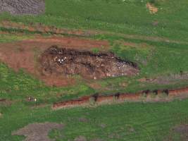 Drone flyover of dead pile at dairy farm - A pile of carcasses and skeletons of calves and cows, mixed in with dirt, on a dairy farm. - Captured at Minko North Dairy, Korunye SA Australia.