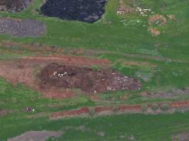 Drone flyover of dead pile at dairy farm - A pile of carcasses and skeletons of calves and cows, mixed in with dirt, on a dairy farm. - Captured at Minko North Dairy, Korunye SA Australia.